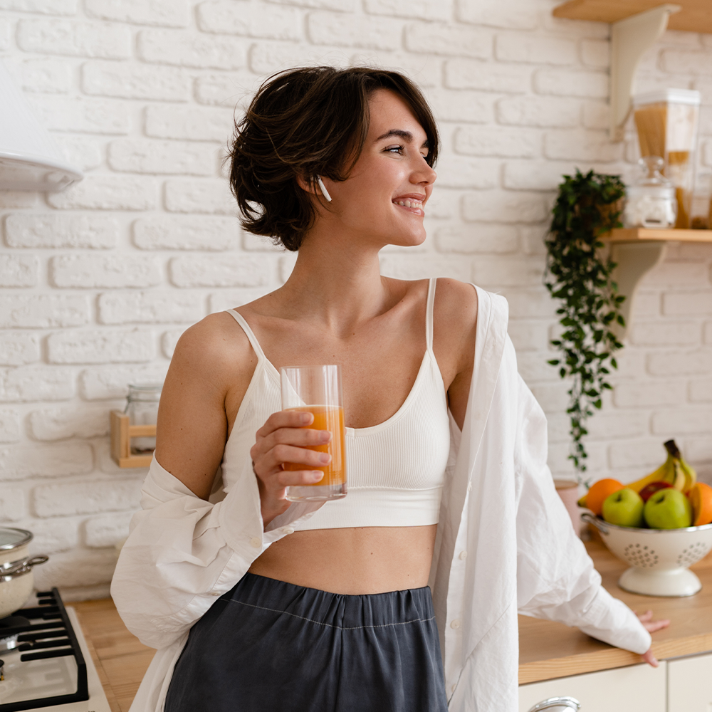 Femme souriante avec un verre de jus à la main